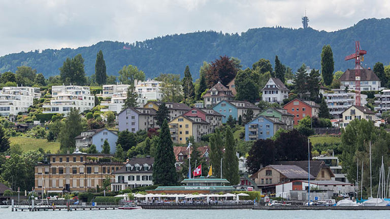 Beautiful pastel homes and hillside vineyards dot the landscape surrounding Lake Zurich. // © 2018 Ben McBee