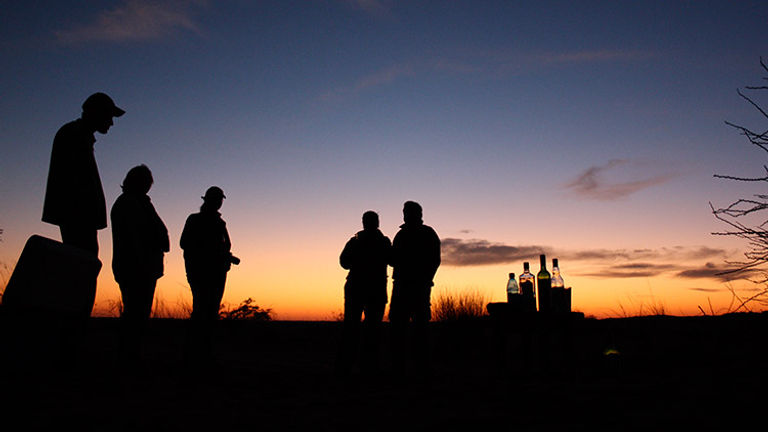 Enjoy a sundowner with the Kalahari sunset. // © 2016 !Xaus Lodge