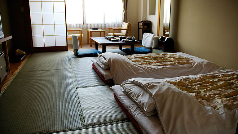 Traditional Japanese futons are placed on the floor at bedtime.